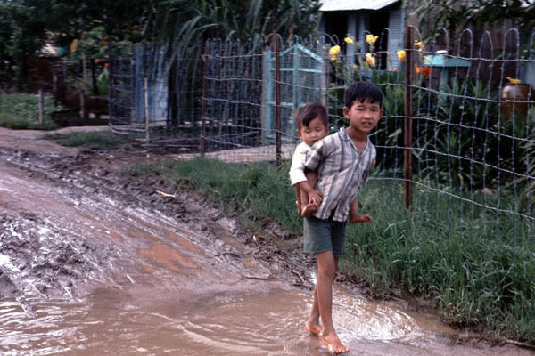 Vietnam 1971- Vietnamese Boy Carrying Brother During Monsoon Season