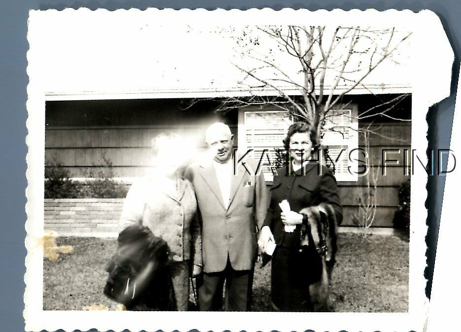 FOUND B&W POLAROID H+9632 MAN IN SUIT POSED WITH WOMEN IN YARDLIGHT ANOMALY
