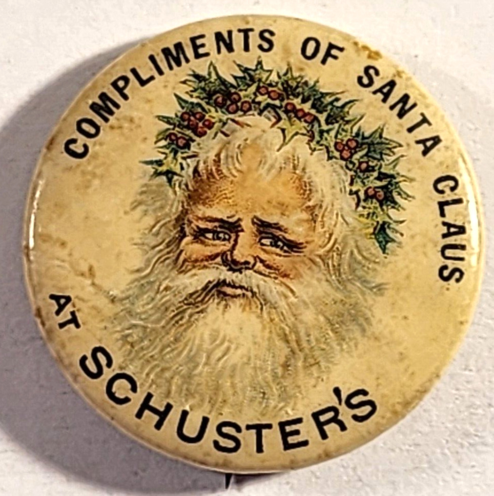 ANTIQUE 1896 COMPLIMENTS OF SANTA CLAUS AT SCHUSTER\'S PINBACK BUTON