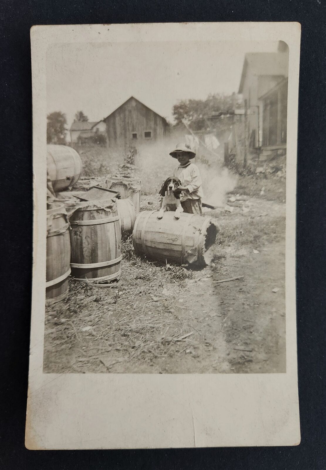 antique RPPC PHOTOGRAPH poverty CHILD DOG on BARREL homes clothes line post card