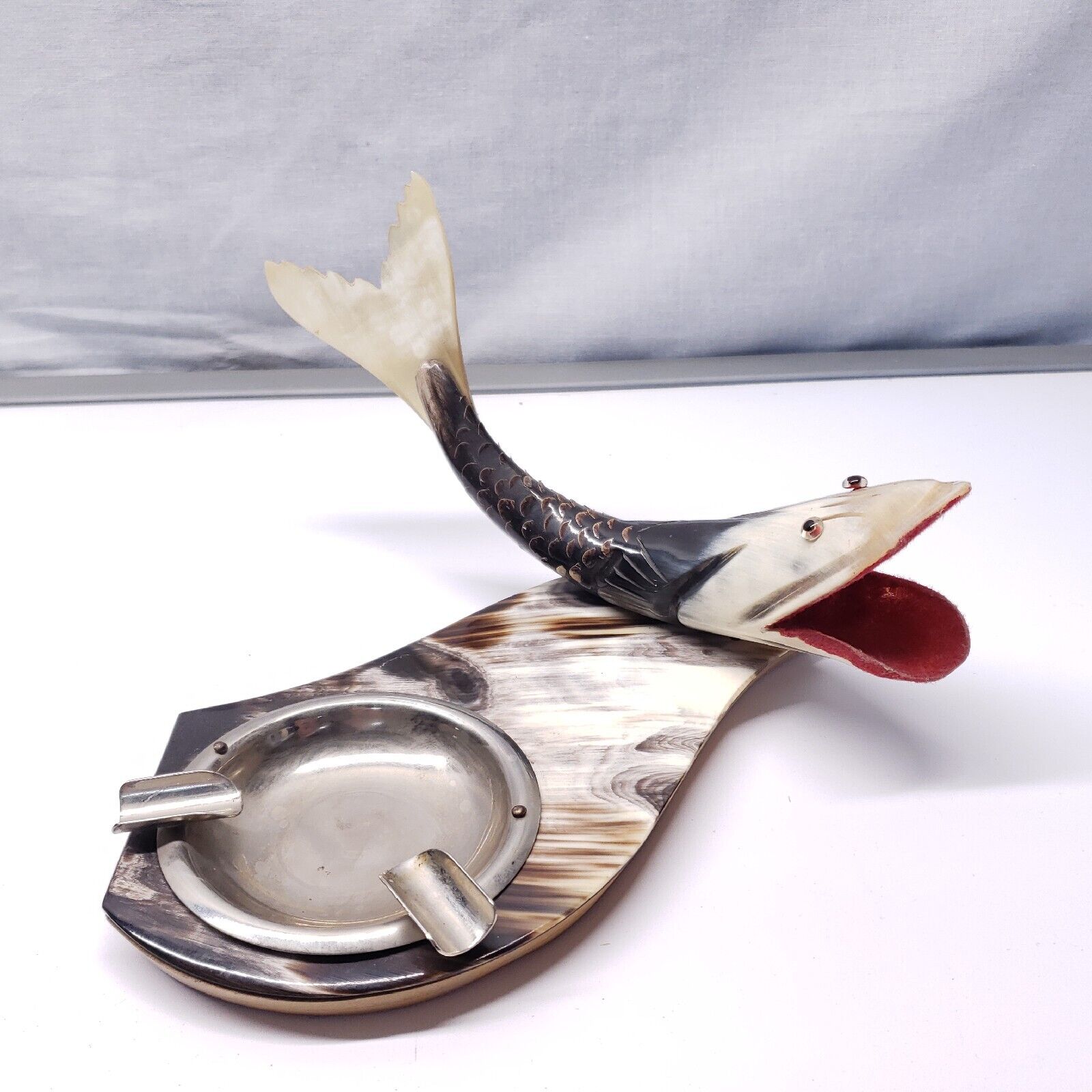 VINTAGE DECORATIVE FISH MADE OF BULLHORN W/ ASHTRAY ON WOOD COVERED W/ BULLHORN.