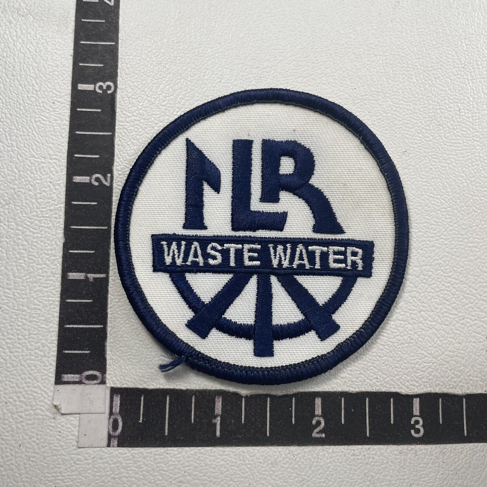 Maybe “LR” (not sure) Wastewater Waste Water Advertising Patch 10RE
