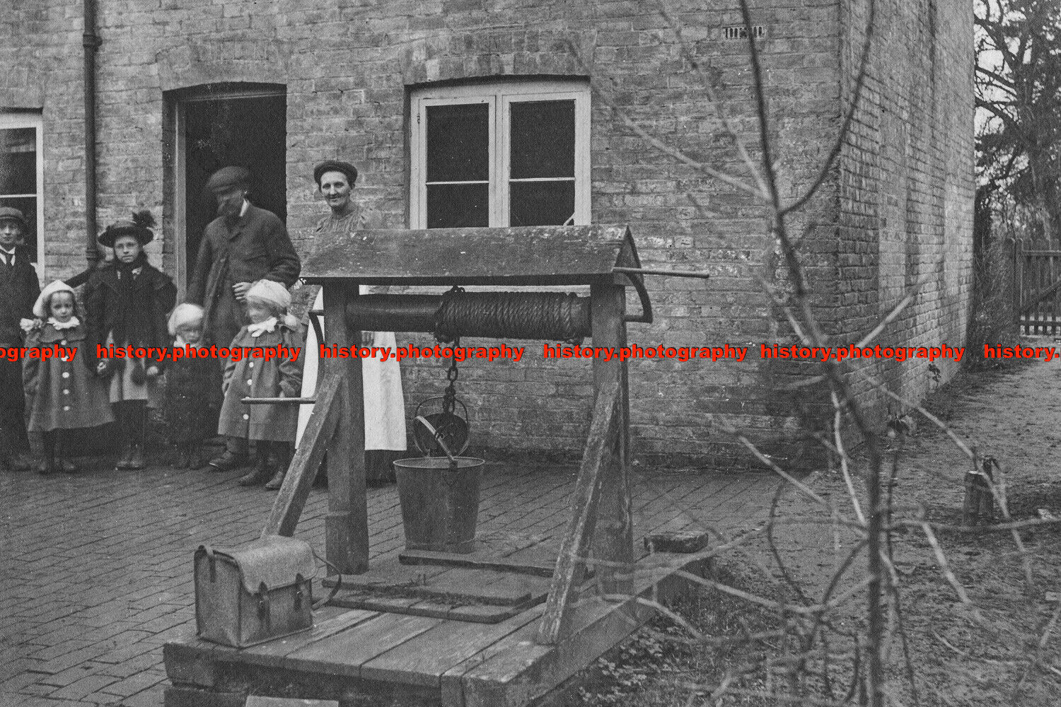 F000859 Photo of family outside house with well and bucket. c1900s. Image shot 1