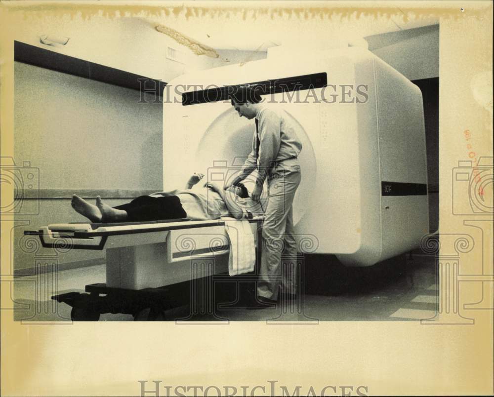 1987 Press Photo A medical technician helps a patient in the MRI machine
