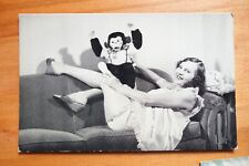 actress/model with chimpanzee doll reclined on couch Moss Photo Service postcard picture