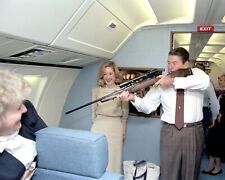 PRESIDENT RONALD REAGAN AIMING A RIFLE ABOARD AIR FORCE ONE - 8X10 PHOTO (RT784) picture