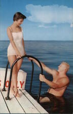 Houghton Lake,MI Man in water climbing up onto the dock toward a woman Michigan picture