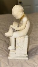 Statue of Child Reading a Book on a Pedestal picture