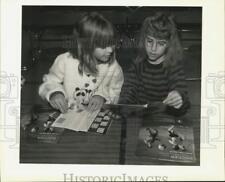 1989 Press Photo Michelle Mokry and Amy Ashley look at stamp kits in Terrytown picture