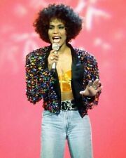 Whitney Houston sings on stage in colorful jacket & jeans picture