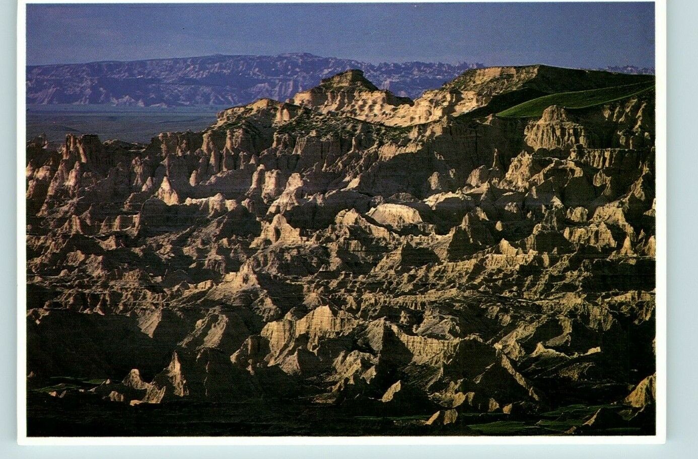 Postcard Badlands National Park South Dakota road expanse erosion of soil 