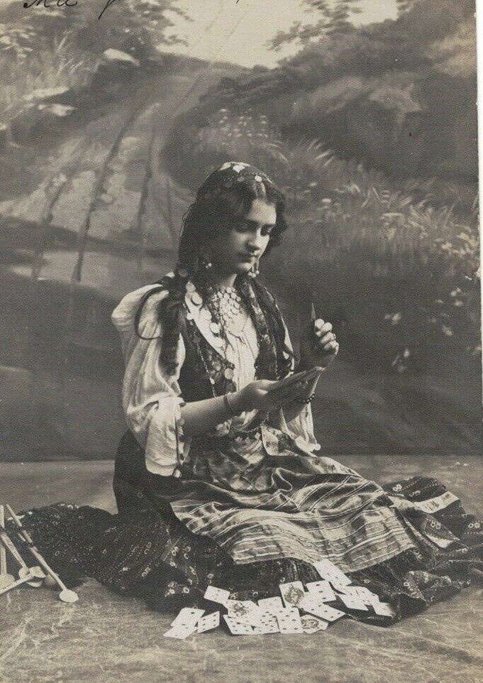 PA2499  GYPSY LONG HAIRED WOMAN PLAYING CARDS SITTING ON THE GROUND RPPC