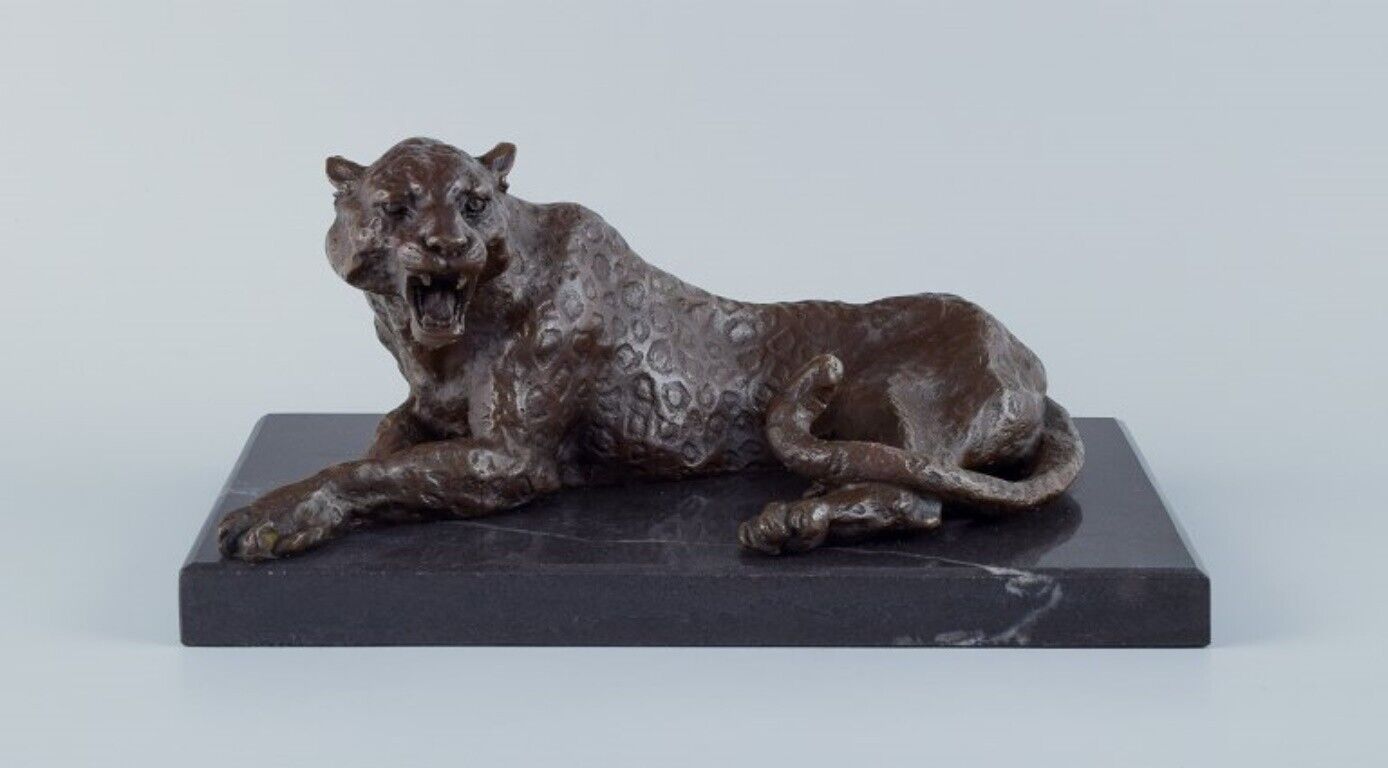 Large and heavy sculpture of cheetah in patinated bronze on a marble base.