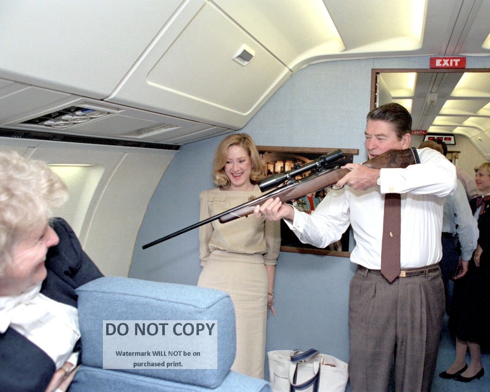 PRESIDENT RONALD REAGAN AIMING A RIFLE ABOARD AIR FORCE ONE - 8X10 PHOTO (RT784)