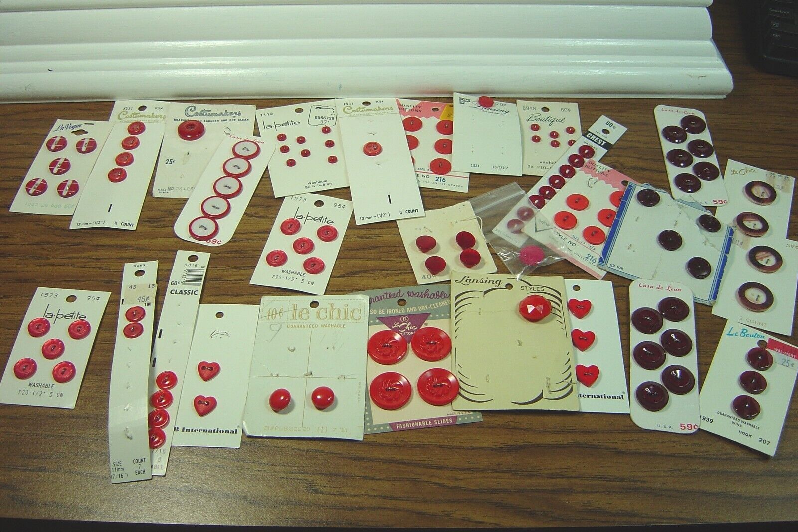 LOT OF RED & BURGUNDY BUTTONS ON CARDS-SOME FULL, SOME PARTIAL