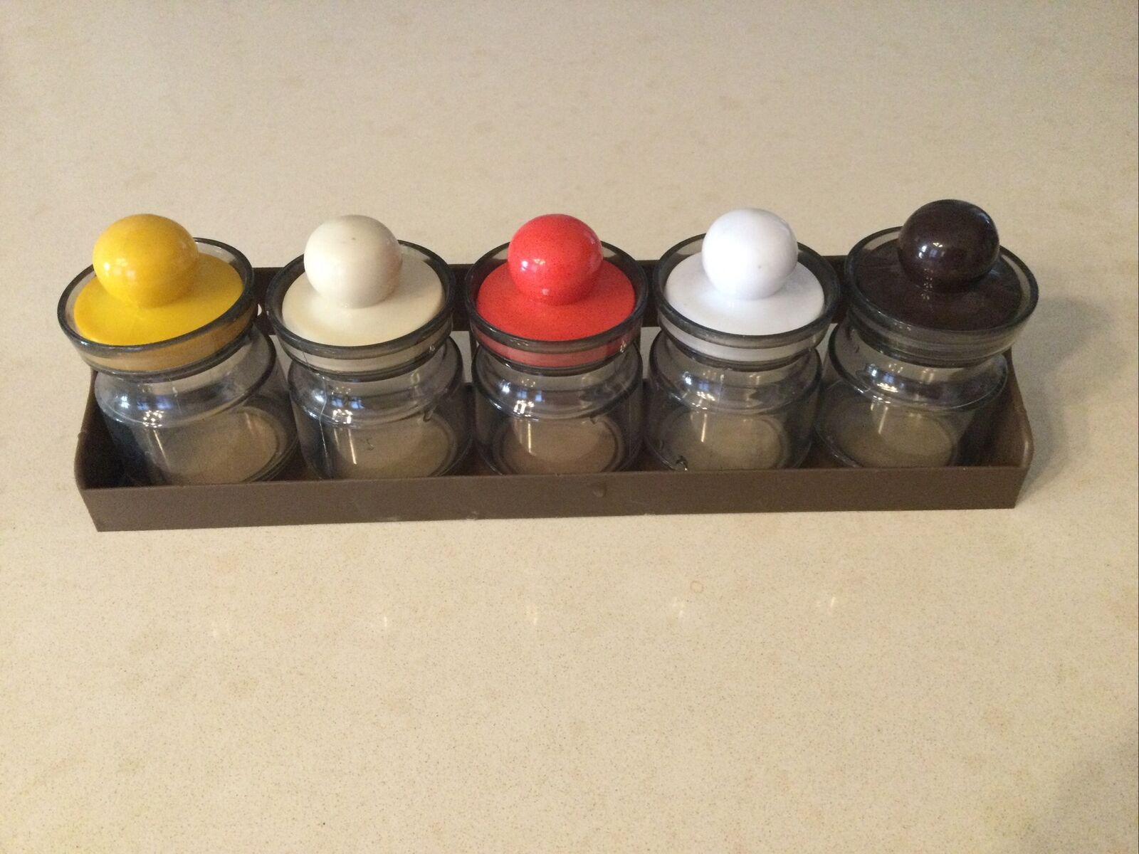 small plastic jars with lids and hanging bracket.