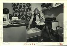 1983 Press Photo Secretary works in office, multi-tasking, on phone - hca52079 picture