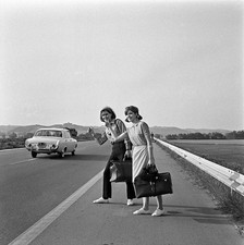 Two young women a low cost holiday hitchhiking street Italy 1960s Old Photo picture
