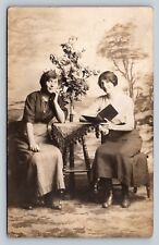 Two Younger Women Studio Photo Beautiful Flowers Reading Nice ANTIQUE Postcard picture