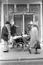 British elderly man carrying a dog a record player a pram Behind h- Old Photo picture